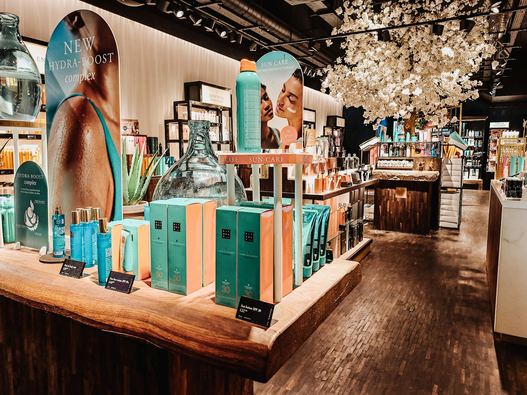 Rituals beauty products on a wood retail table with branded risers and header panels
